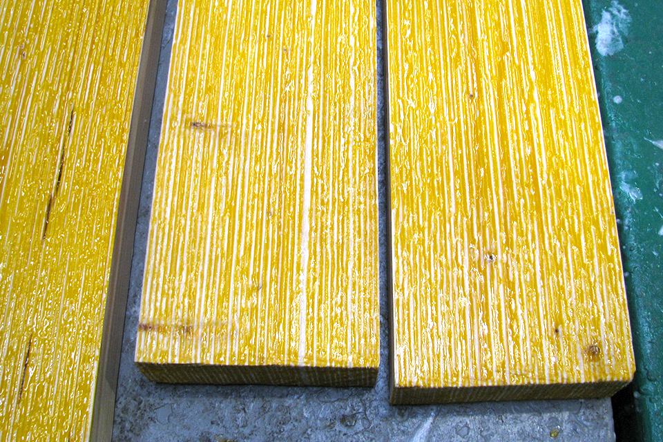 Three wooden boards with a yellowish shimmering surface coating.