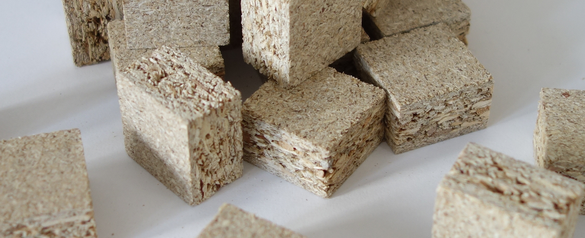 Small chipboard samples lie in a pile.