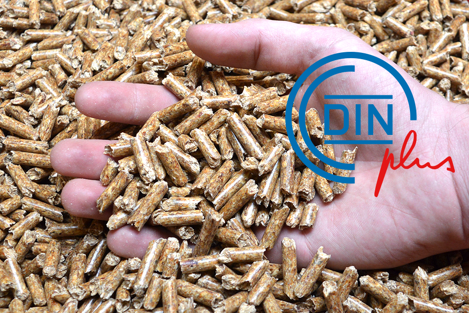 DINplus-Logo vor Foto von einer Hand die in einen Haufen Pellets greift.